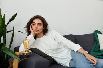 Resting in a modern apartment, a young woman finds peace in her cozy space