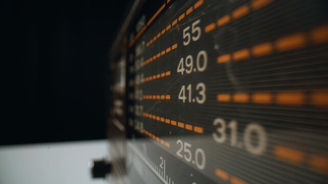 Macro panel FM waves at vintage analog radio in dark apartment. Needle moving
