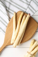 Raw asparagus spears on white wooden table, flat lay