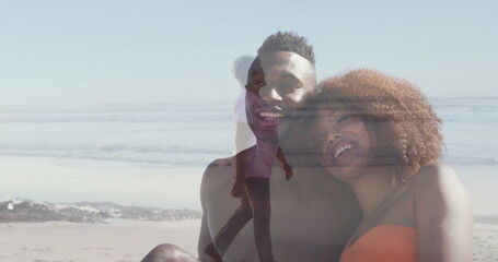 Smiling couple in swimwear leaning close and ghostly woman walking shore at beach, double exposure