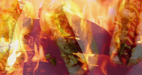 Grilling sausage-filled buns over open flame grill grate, with cheese, ketchup, mustard, jalapeños