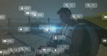 Sitting man wearing life vest on beach at sunset with surf wing, social icons, copy space