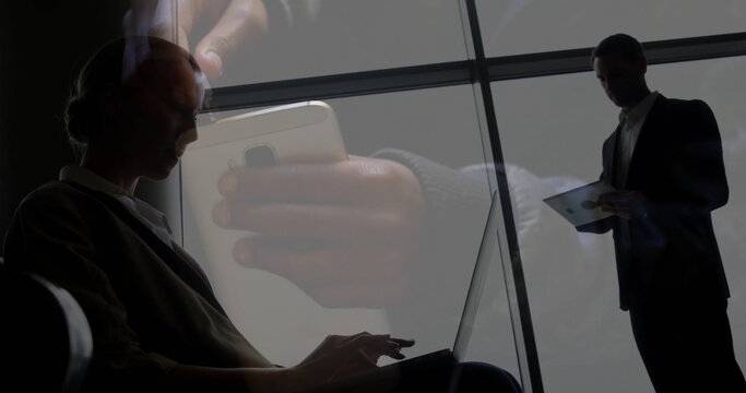 Typing businesswoman on laptop in lobby by grid windows with tablet, smartphone copy space
