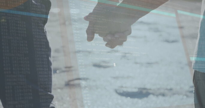 Walking couple wearing jeans and light pants holding joined hands on sunlit road, with code overlay - Powered by Adobe