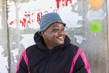 Africa village, single young african traveler man waiting in a bus station, taking a trip, wearing...