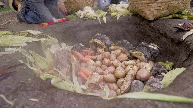 Proceso tradicional de preparaci&oacute;n de alimentos bajo tierra llamado Pachamaca, gastronom&iacute;a ex&oacute;tica en Otavalo, Ecuador 
