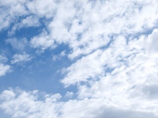 Fluffy white clouds against a bright blue sky