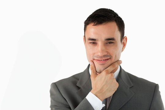 Male professional standing against white backdrop in studio, wearing grey suit jacket, copy space