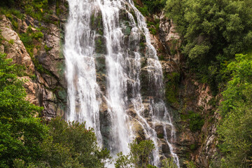 Waterfall falling from the rocks and trees around it in middle of forest and mountain in Jijel, Algeria, Africa, Beautiful waterfall for landscape, River waterfall, rain water and stream, water fall.