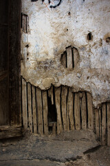 damaged wall with cracked plaster and wood