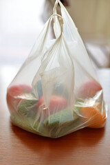 Colorful soap bars wrapped in a plastic bag on a wooden table with soft lighting
