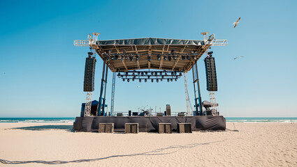 Outdoor concert stage setup on beach with sound equipment and lighting system ready for summer music festival performance