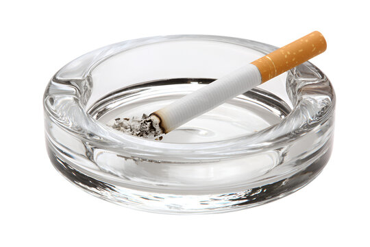 A burning cigarette in a glass ashtray