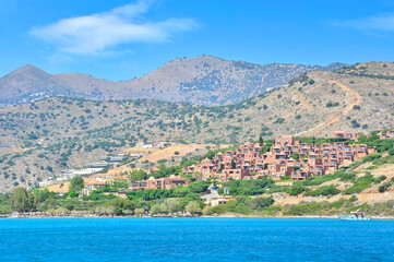 Overview of the  popular tourist landmark Plaka village and rocky hills in the background, Crete, Greece
