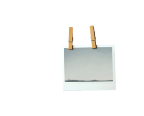 A small, square, instant photo, light gray tones, attached to a dark background with wooden clothespins