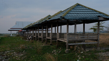 Row Of Wooden Gazebos In Rural Landscape