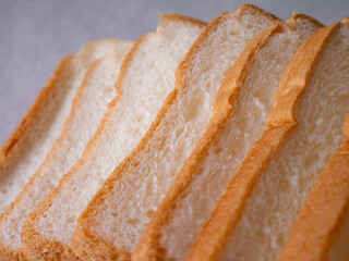 Toasted white bread loaf sliced on white background.