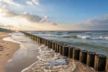 Obraz premium Peaceful Beach Shore with Wooden Breakwater and Ocean Waves 