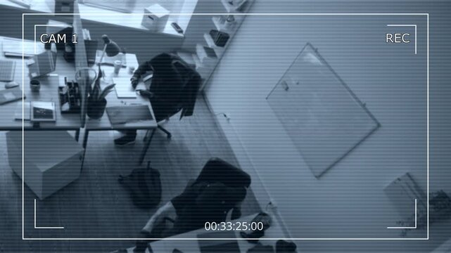 Security camera footage of two male criminals wearing masks hacking into corporate laptops while breaking into office during industrial espionage