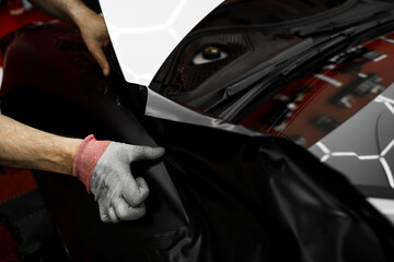 Matte black vinyl wrap application on front fender and wheel arch of luxury vehicle. Vinyl Wrapping...