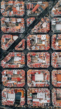 Aerial view of the city's grid-like pattern, where terracotta rooftops meet the dark asphalt streets, creating a striking contrast in the urban landscape, Valencia, Valencian Community, Spain.