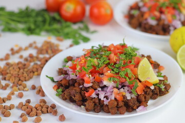Chana Chat, also known as chickpea salad, served with chopped tomatoes, onions, cilantro, and lime