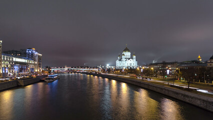 Fototapeta premium Majestic orthodox Cathedral of Christ Saviour illuminated at dusk on bank of Moscow river. Timelapse hyperlapse, Russia