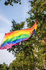 A colorful rainbow flag waves in the summer air during pride celebrations in Barcelona. The lively atmosphere reflects joy, acceptance, and unity among the LGBTQ+ community.