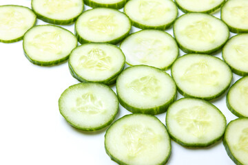 Background created from green ripe natural organic cucumber sliced into circles on white background