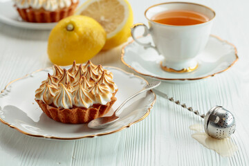 Meringue lemon tart on a white wooden table.