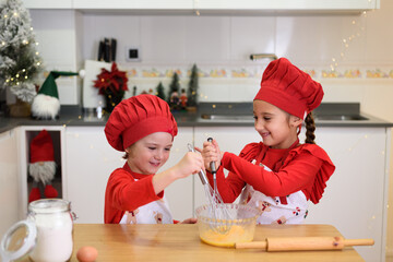 Happy children whisking eggs, making christmas cookies in kitchen
