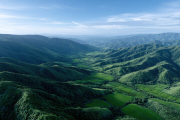 Naklejka premium Breathtaking aerial view of lush green valley surrounded by rolling hills