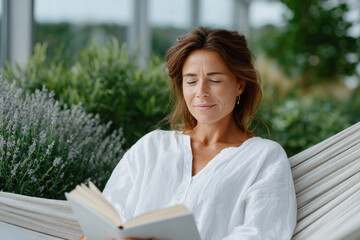 Serene woman reading in hammock surrounded by lavender and greenery