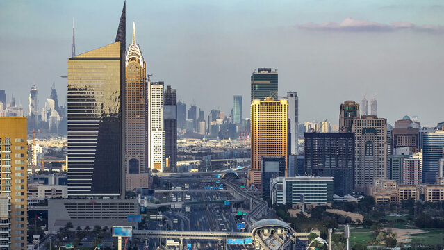 Aerial view of Dubai marina skyscrapers and Internet city towers timelapse with traffic on sheikh zayed road.