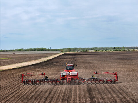 Red tractor pulling a red Vacuum Hydraulic Drive 24 row planter