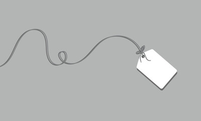 White rectangular tag with rounded corners hanging from a string with a bow on a soft background