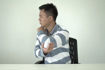 Man having tensed muscles fatigued, neck, shoulder, back, wrist and arm pain during work long time...