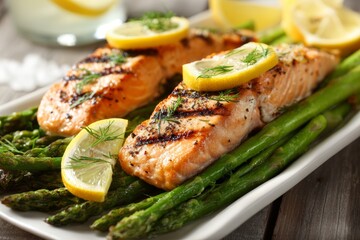 Close-up view of a plate featuring grilled salmon fillets garnished with lemon slices, accompanied by vibrant asparagus. Ideal for a healthy dining experience