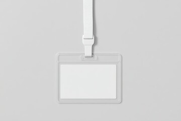 A horizontal transparent plastic ID card holder with a blank white card inside, hanging from a plain white lanyard, centered and viewed from the front, on a smooth, light gray, textureless background