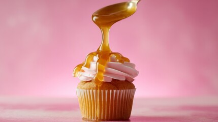 A Delicious Cupcake with Sweet Caramel Drizzle displayed beautifully on a Pink Background