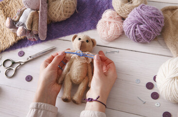 Process of making vintage toy, top view. Artisan pov, needlewoman hands sewing handmade teddy bear,...
