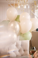 background for a holiday in beige and green tones consisting of balloons