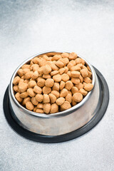 Dog food in a silver bowl. Dry animal feed in a bowl close up.