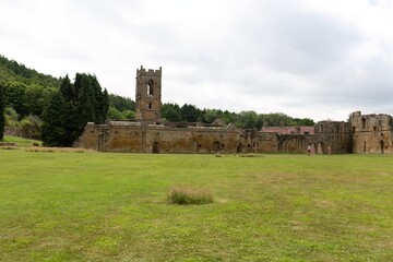 the ruins of an old stone building or castle on a grassy field under a cloudy sky in Mount Grace Priory - East Harlsey - North Yorkshire - UK
