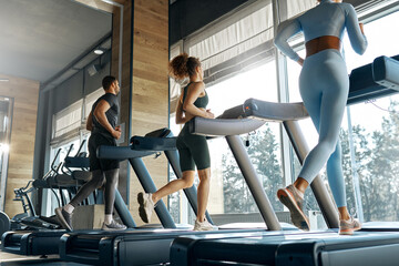People running on treadmills in modern gym