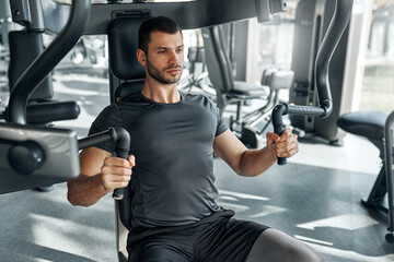 Man working out on chest press machine at gym