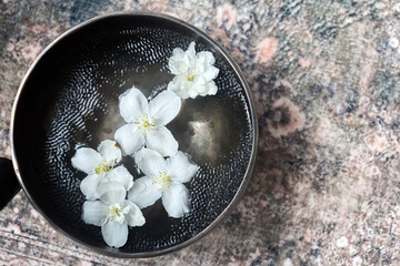 Serene Floral Arrangement. Elegant white flowers float in a black singing bowl, creating a tranquil...