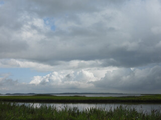 The natural beauty of the wetlands, as the remnants of tropical storm Debby pass by. Ominous clouds looming in the sky above the Bombay Hook National Wildlife Refuge, Kent County, Delaw