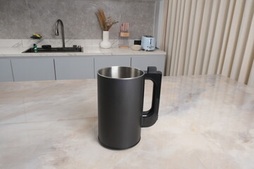 Modern black nut milk maker or blender placed on a kitchen countertop with a minimal background....