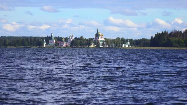 View from the water at Valdai Iversky Svyatoozersky Virgin Monastery for Men. Selvitsky Island, Valdai Lake. View of the Valdai Iversky Bogoroditsky svyatoozersky monastery. Sunny June day,
